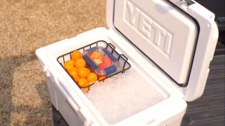 A Yeti cooler filled with ice, drinks, and food