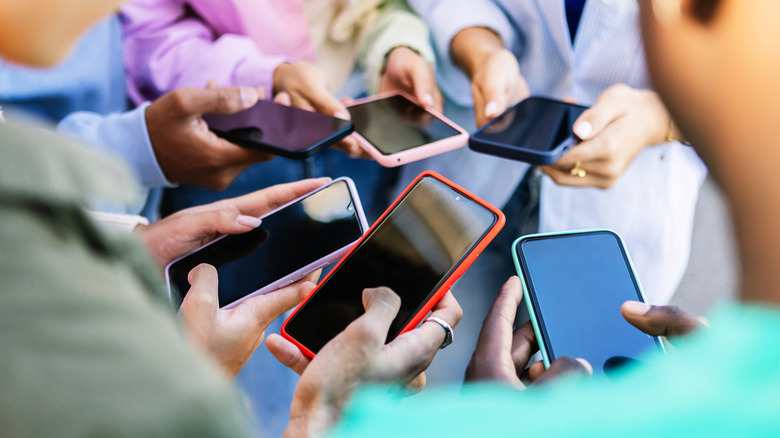 Group of people holding smartphones.
