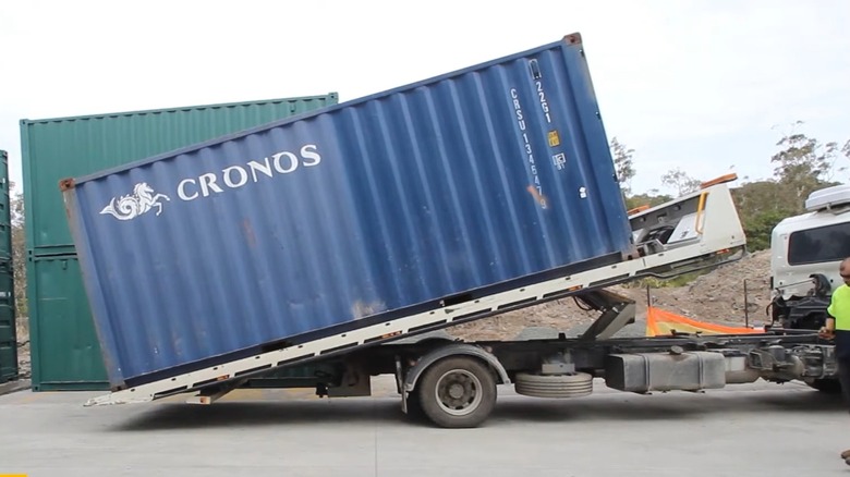 A Tilting Truck Tray Delivering A Shipping Container