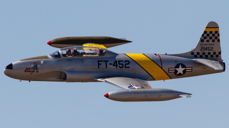 A T-33 Shooting Star flying over blue skies at an air show in 2014