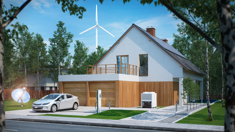 A home with a wind turbine behind it.