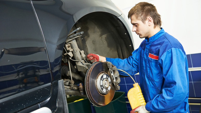 A mechanic replacing a car's brake fluid.