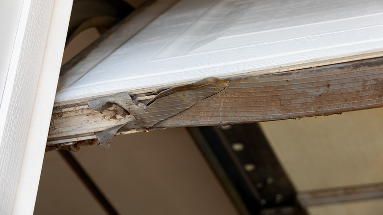 Close-up of a torn garage door seal.