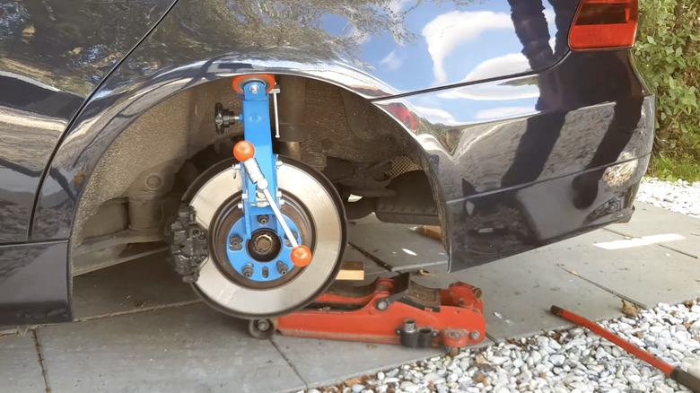 Fender roller mounted on a car's wheel hub to roll the rear fender lip