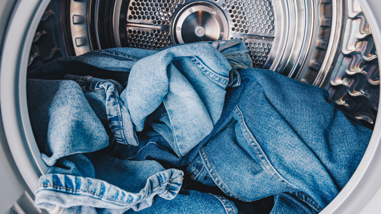 Picture showing blue jeans inside of a washing machine