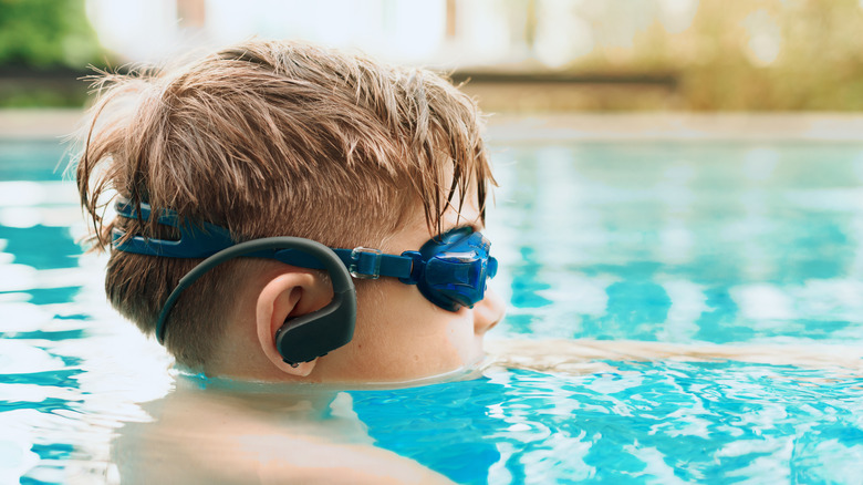 Boy swimming with waterproof headphones