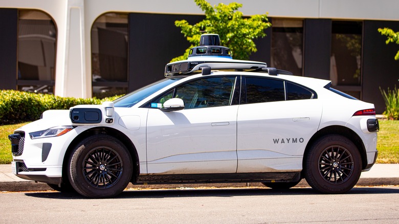 Side view of a Waymo car on curb