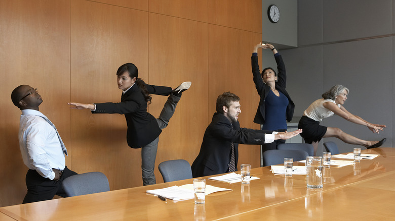 people stretching in office meeting room