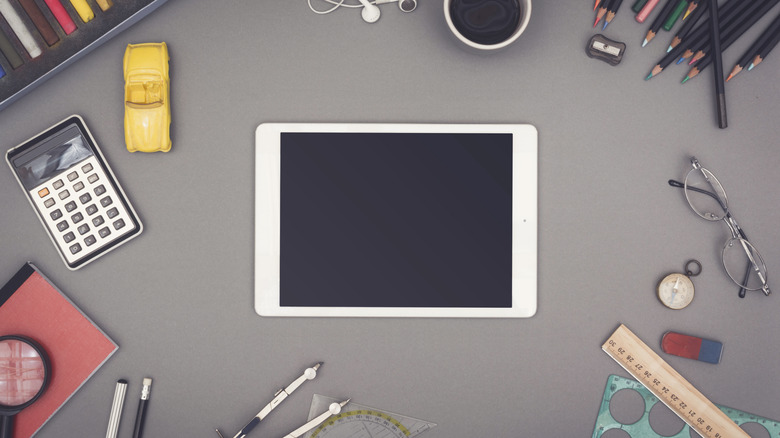 old ipad on a desk with office supplies