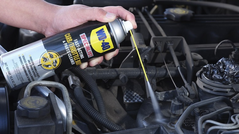 person using WD-40 Specialist Carb/Throttle Body Cleaner