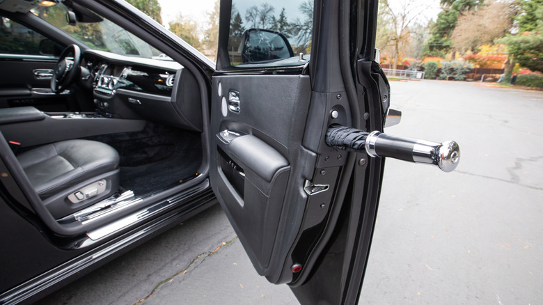 A close-up of a black Rolls Royce Ghost showing its in-door umbrella.