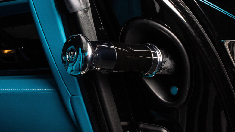 A Rolls-Royce-branded umbrella popping out of a vehicle door