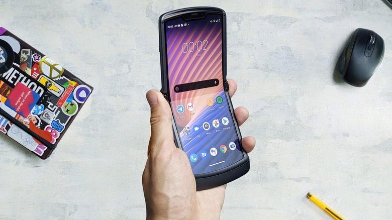Motorola Razr 2 in hand above desk