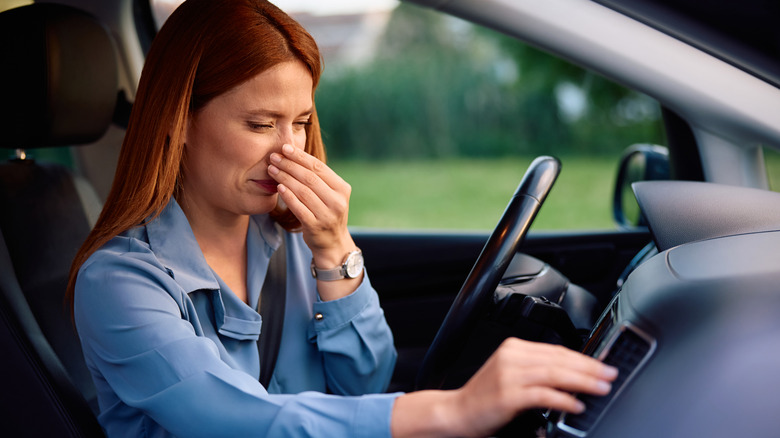 Woman holding nose