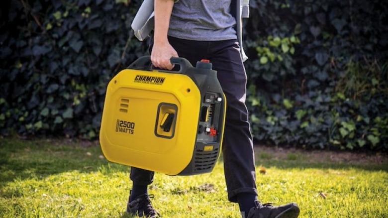 The Champion 2500-Watt Inverter Generator being carried by one hand.