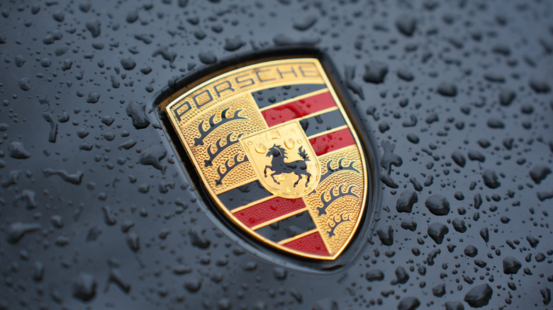 Close-up of a rain-soaked Porsche badge