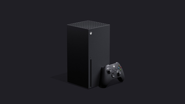 A picture of the xbox series x and controller against a black background
