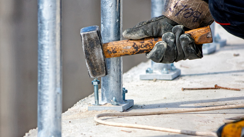Close-up shot of concrete anchors being hammered
