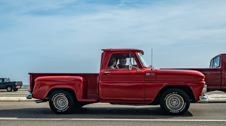 Side shot of a red 1965 Chevrolet C10 stepside pickup truck