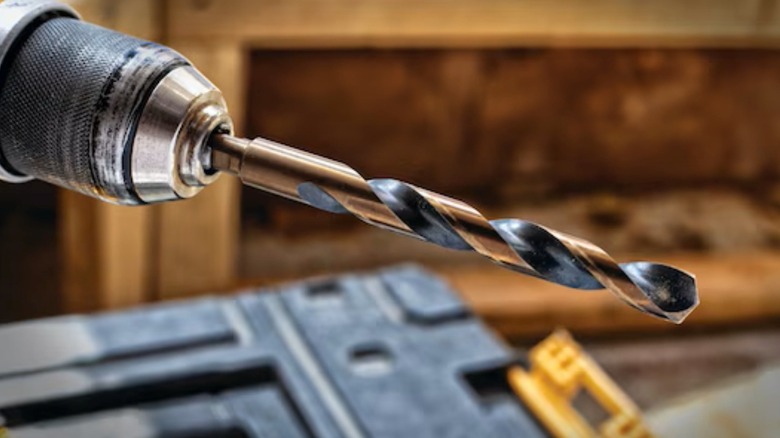DeWalt's Black and Gold drill bit chucked in drill for drilling.