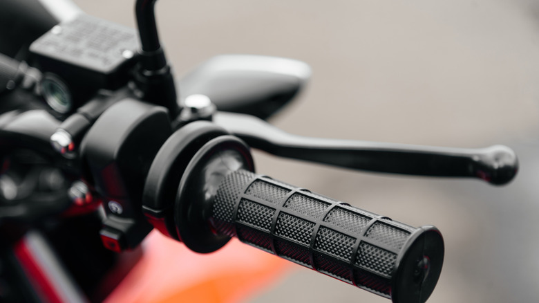 Close-up of red and black motorcycle handlebar.