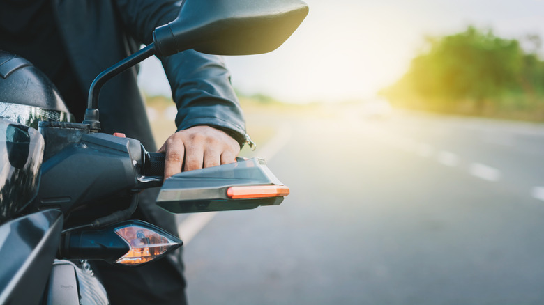Close-up of hands on motorcycle handlebars