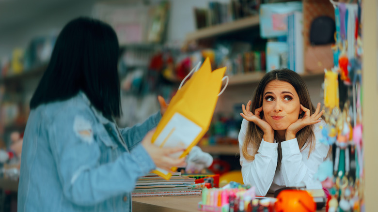 Customer returning products to an unenthusiastic cashier