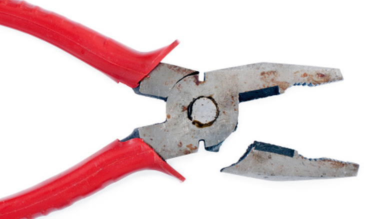 A broken pair of cheap pliers against a white background.