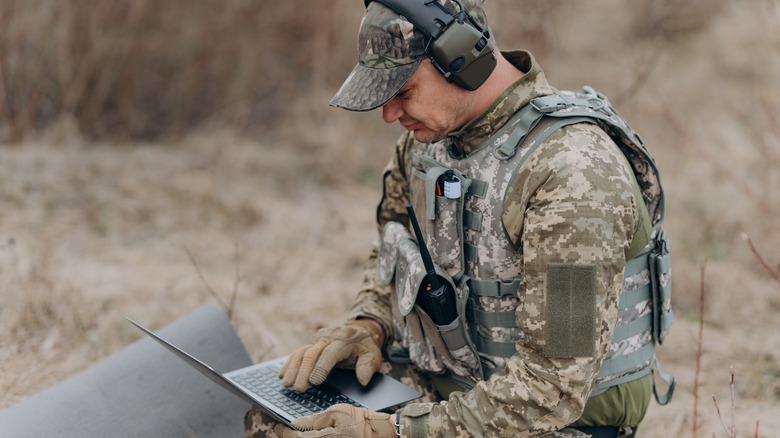 soldier using laptop in the field