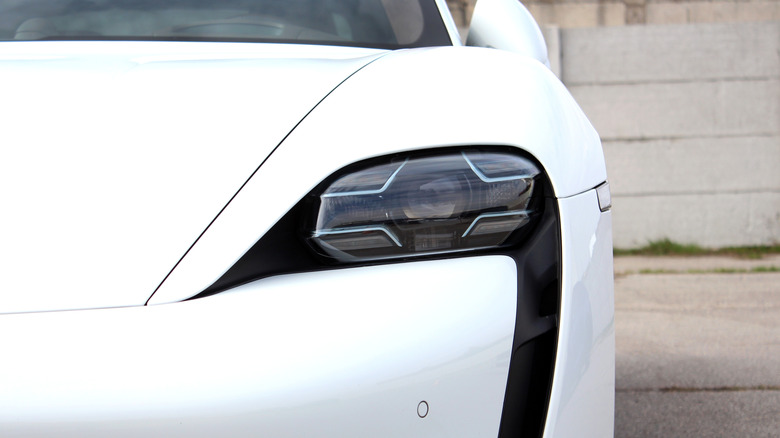 An irregularly shaped headlight of a colored car.