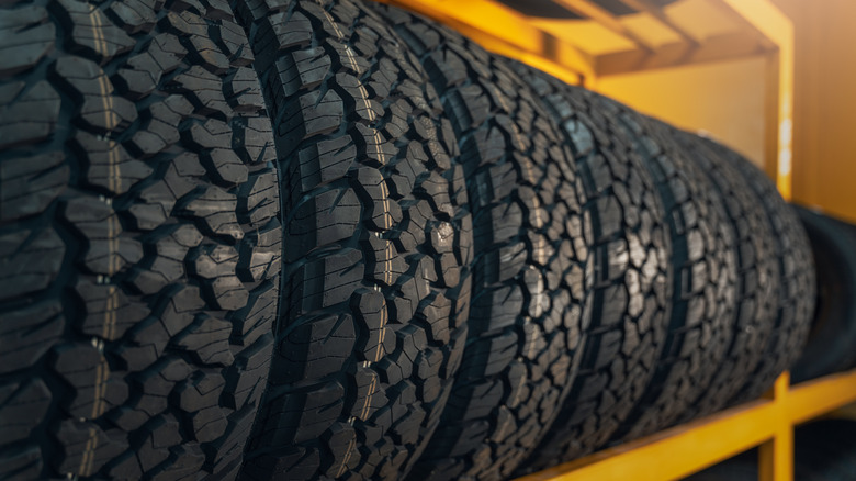Mud-terrain tires stacked next to each other on a rack