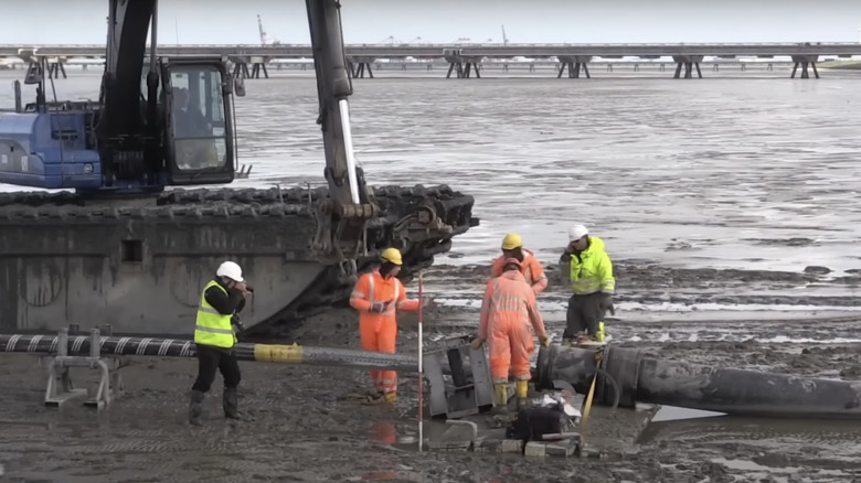 men laying submarine cable