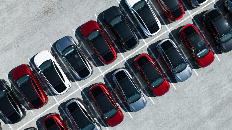 Red, white, and silver Tesla Model Ys parked, shot from above