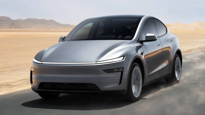 Silver Tesla Model Y driving on a desert road