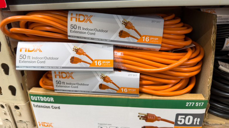 Three-pronged extension cords for sale in a hardware store.