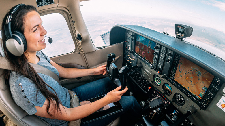A female pilot behind the controls of a small plane