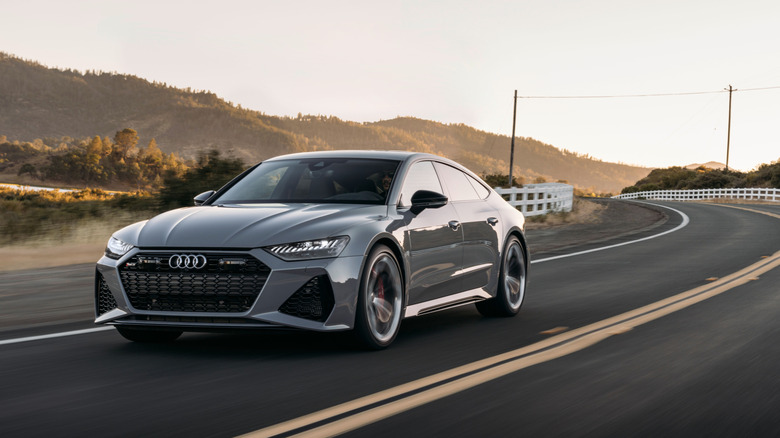 Front view of gray Audi RS7 driving on rural mountain road.