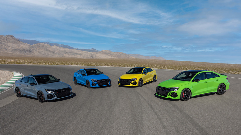Overhead view of multicolored Audi RS3s parked on desert race track.