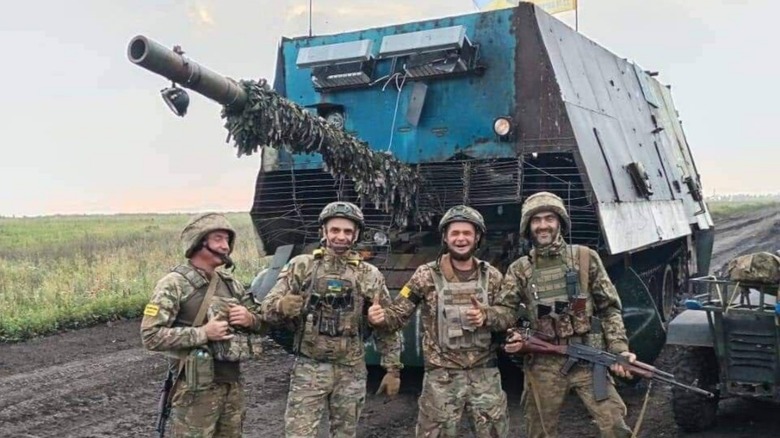 Ukrainian soldiers posing before a captured Russian Turtle Tank.