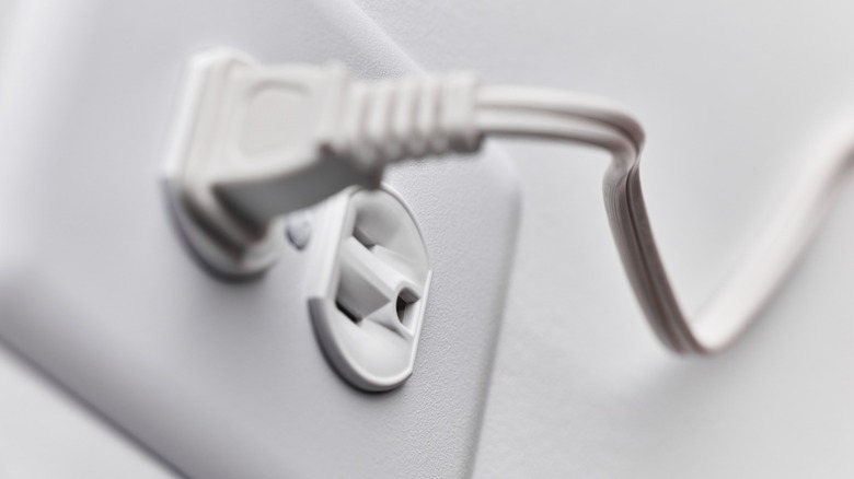 a two-prong electric plug attached to a wall outlet