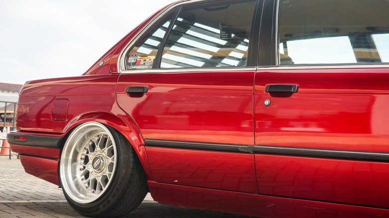 The rear of a BMW E30 showing the rubber strip on both the front and rear doors