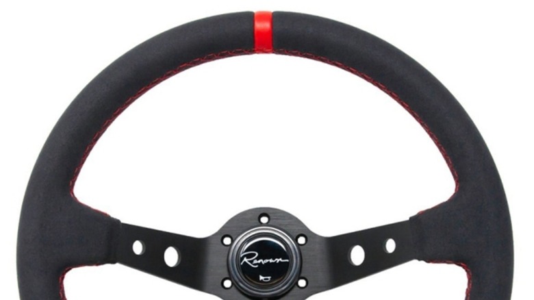 A sports steering wheel with a red stripe on its 12 o'clock position.