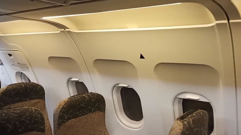 A black triangle sticker right above the window seat in a plane