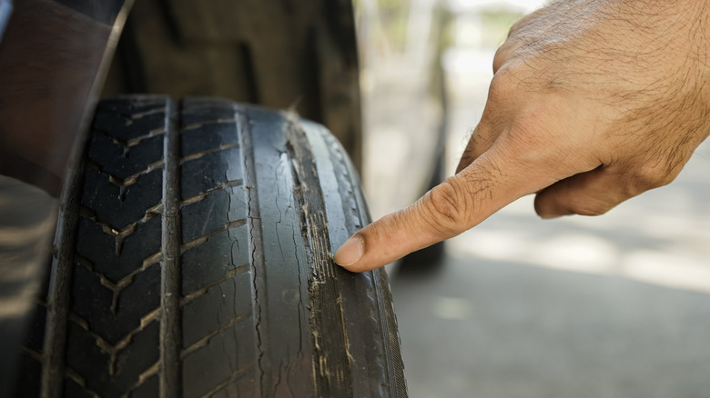 Uneven wear on a tire being pointed out