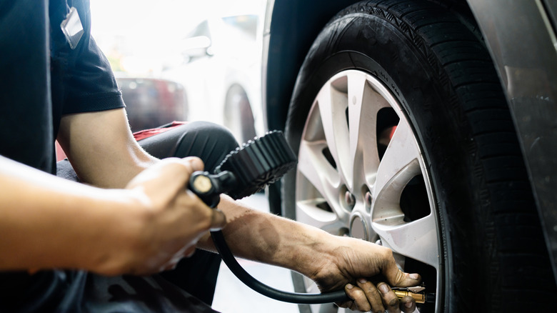 Tire pressure gauge being used to check pressure