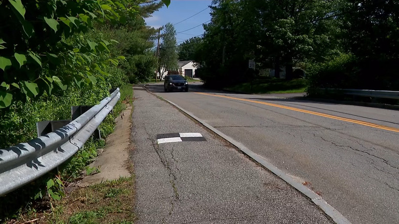 A black and white ground control point (GCP) on the side of a road.