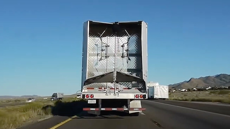 Rear view of a sem-truck trailer driving on the highway with a trailer tail