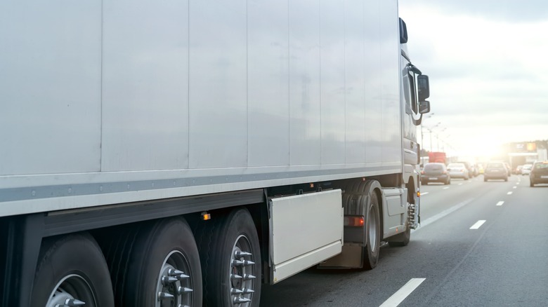 White semi-truck with spiked lug nuts on a highway