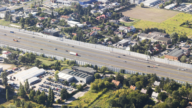 Aerial view of wide highway with highway traffic noise barriers