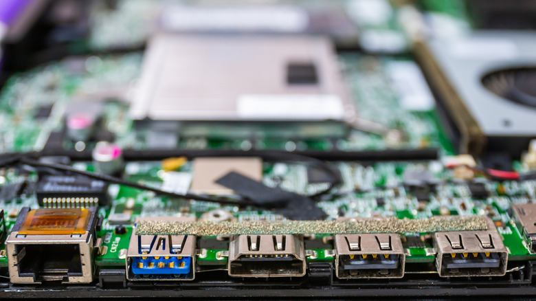Close-up of the inside of a laptop motherboard with various connection ports